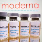 FILE PHOTO: Vials and medical syringe are seen in front of Moderna logo in this illustration